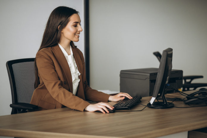 Young business woman working on laptop in office