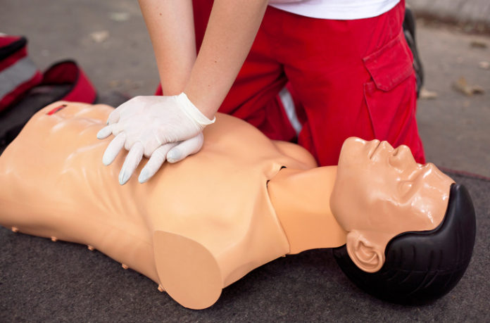 Man administrating CPR on a mannequin