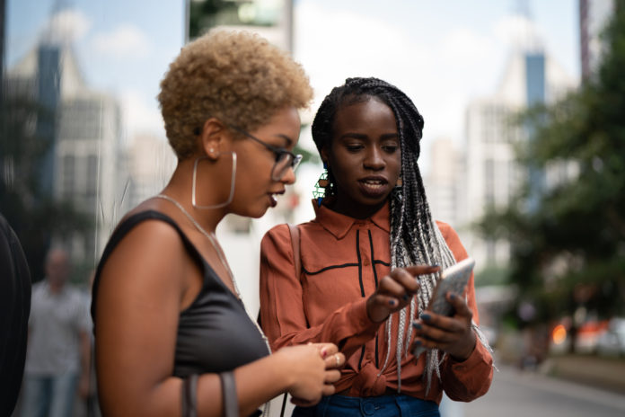 Two Businesswoman Get Directions on Mobile